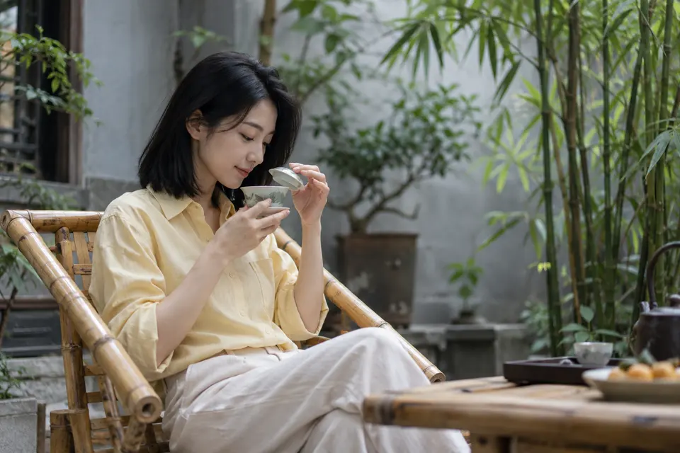 成都庭院里的竹椅与盖碗茶席，光线落在茶桌上